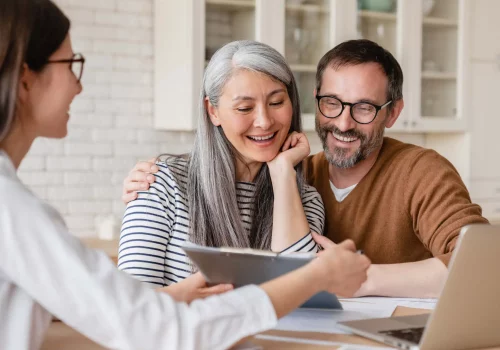 a realtor showing two home buyers an ipad